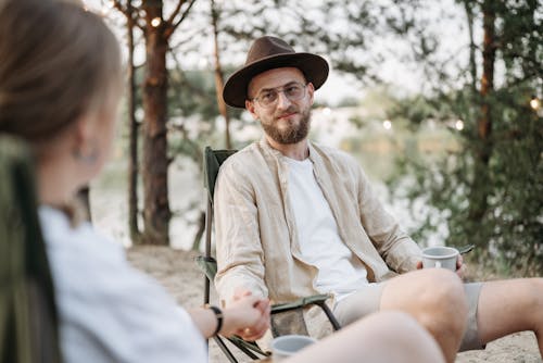 Bearded Man Wearing a Hat Holding Hands with a Woman