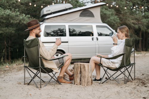 Couple Sitting on Camping Chair Drinking Coffee