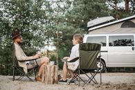 A Man and Woman Having Conversation while Sitting on Folding Chairs