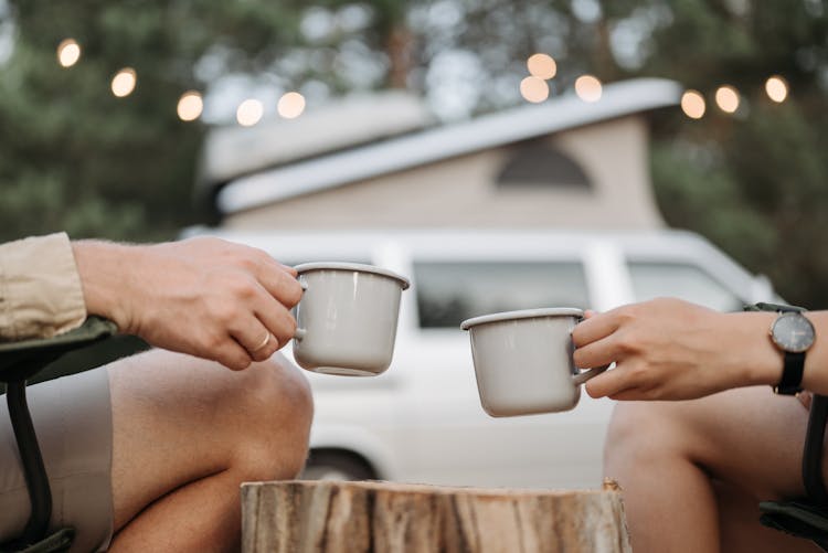 People Holding Ceramic Mugs