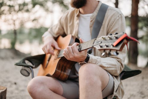 A Man Sitting while Playing Guitar