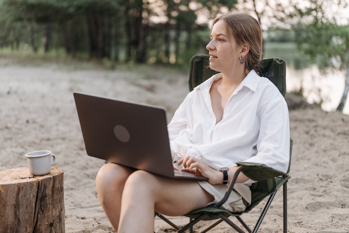 Woman Sitting on a Chair Using Laptop