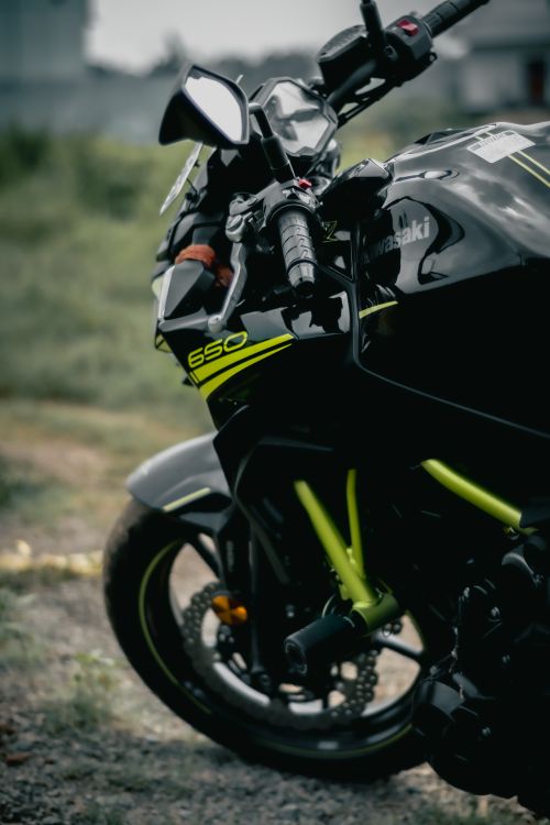 Free Close-up of a black sports bike with green accents parked outdoors. Stock Photo