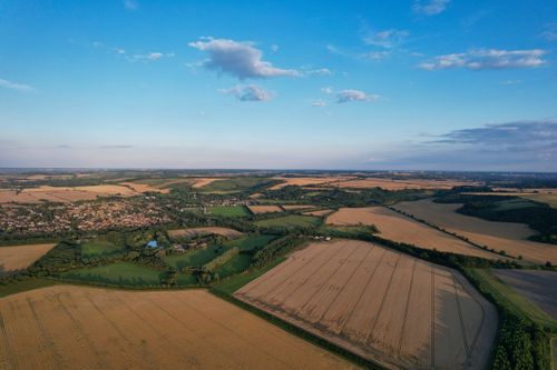 Free Drone image showcasing lush fields and villages in Central Bedfordshire, UK under a bright summer sky. Stock Photo