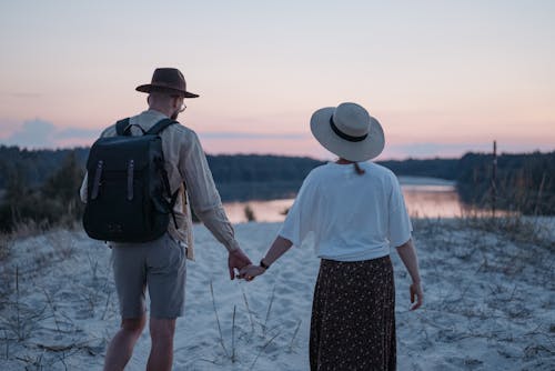 Back View of a Couple Walking on a Beach and Holding Hands 