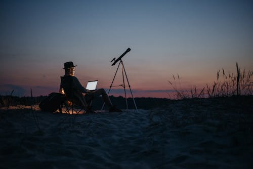 A Person Using a Laptop Outside at Night
