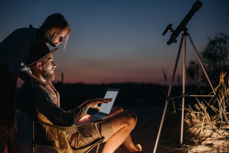 A Man Using A Laptop At Night