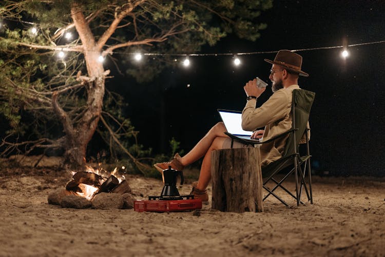 A Man Using A Laptop At Night