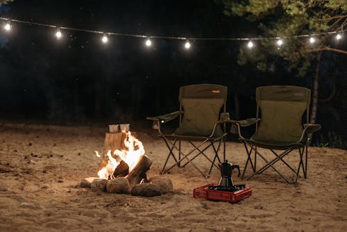 Black Chairs beside a Campfire