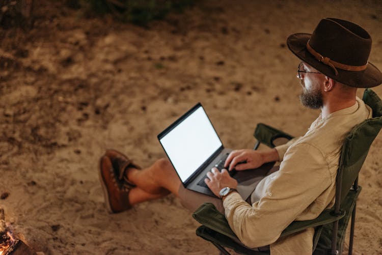 A Man Using A Laptop At Night