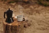 White Ceramic Mug on Brown Wooden Log