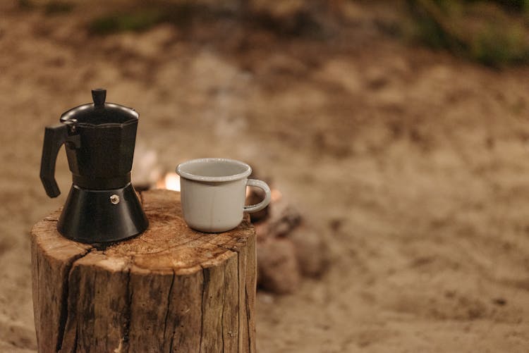 A Ceramic Cup On A Wooden Log