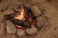 A Burning Woods Near the Rocks on the Sand