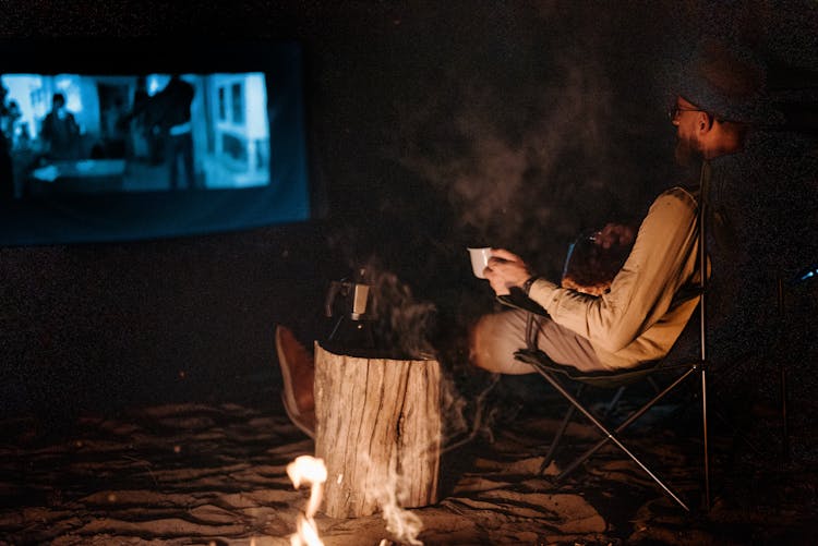 Man Watching Movie In Wilderness At Night