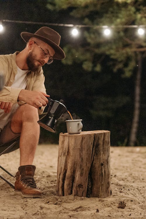 A Man Pouring Hot Coffee in a Cup
