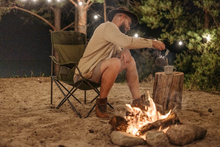 A Man In Brown Long Sleeves Sitting On Camping Chair