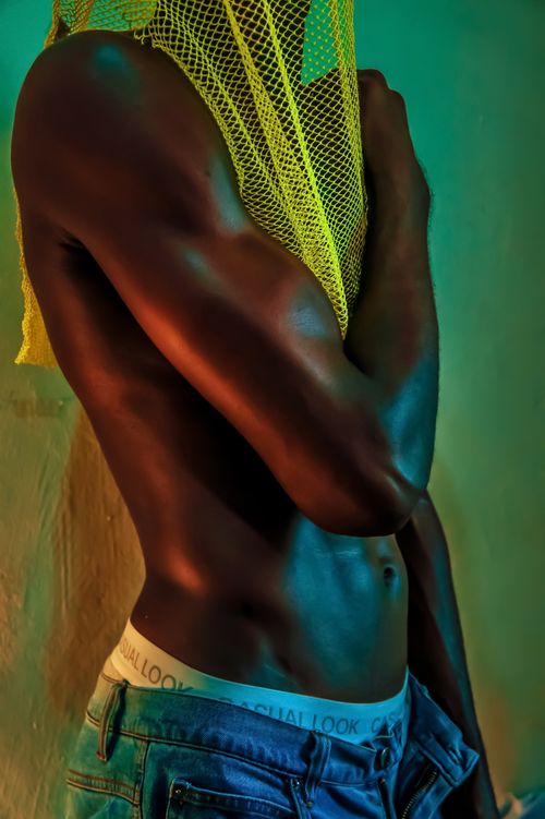 Free Artistic shot of a man in jeans and underwear with vibrant colorful lighting. Stock Photo
