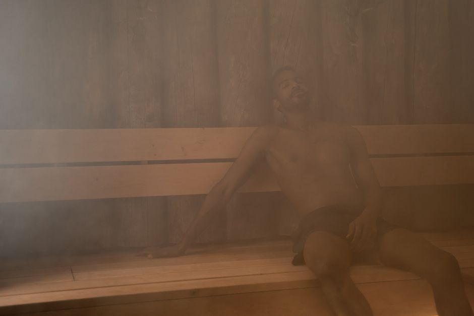 man relaxing in a steamy sauna, enjoying the warmth and tranquility.