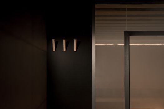 A minimalist interior design featuring sleek wall hooks and subtle lighting, capturing modern simplicity.