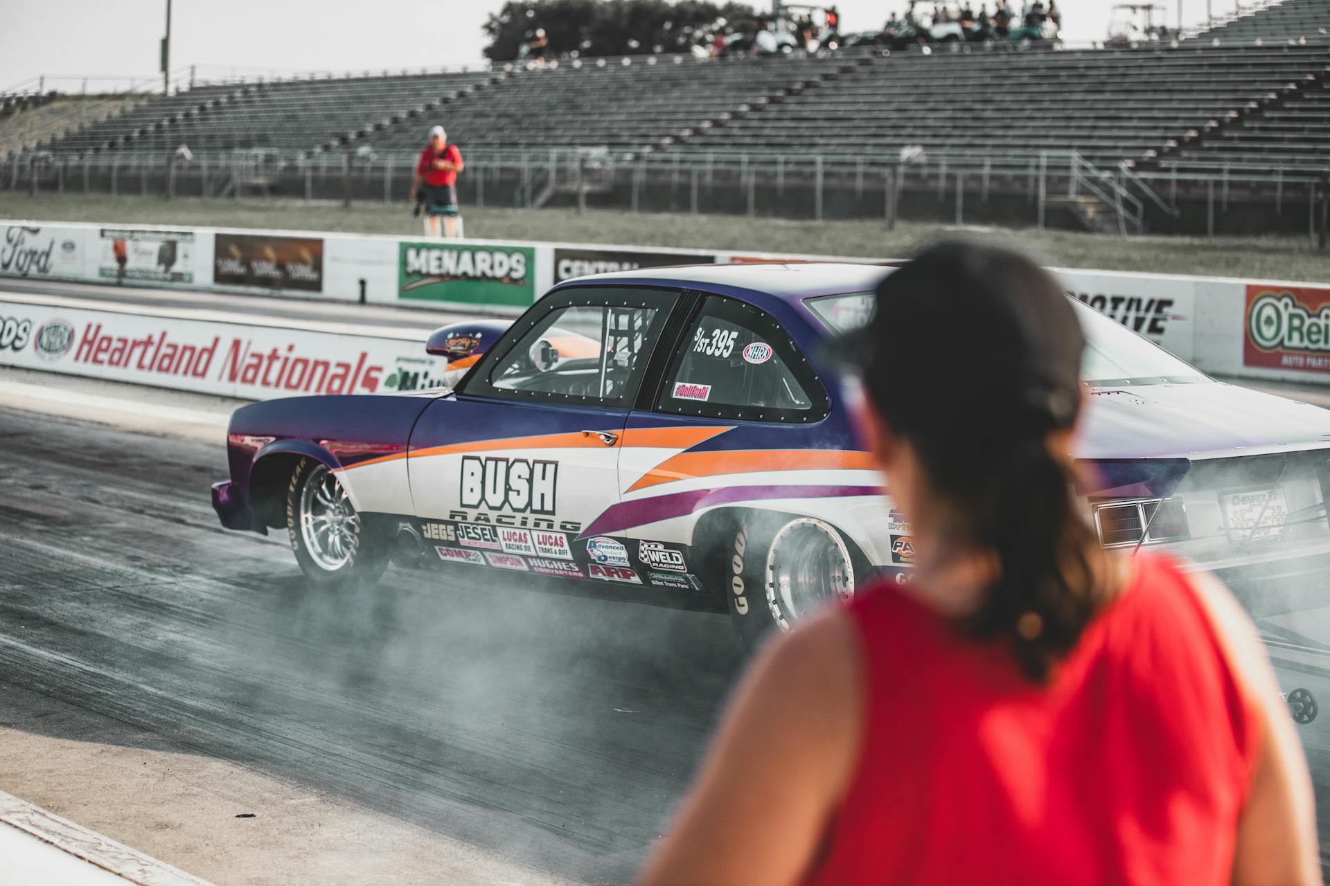 A thrilling drag race event at Heartland Nationals in Topeka, showcasing modified race cars and dynamic competition.