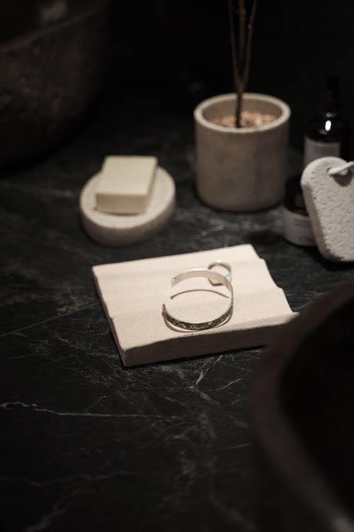 Close-up of a Bracelet and Ring Lying on a Bathroom Countertop 