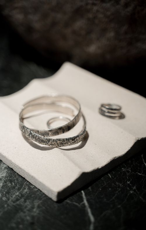 Free Close-up of elegant silver rings placed on a textured stone background, highlighting design details. Stock Photo