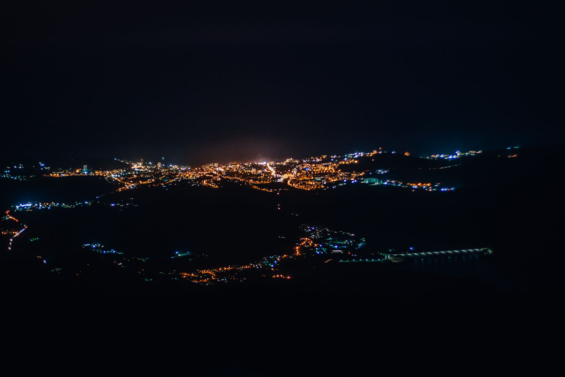 Gece gökyüzünde uçan insansız hava araçları ve şehir silüeti