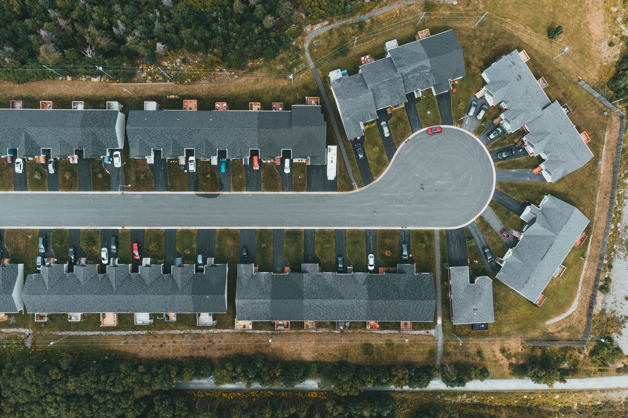Aerial view of townhouses with dark asphalt driveways