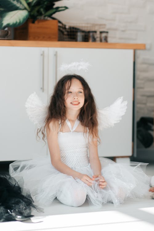 Free A Pretty Girl in Angel Costume Sitting on the Floor Stock Photo