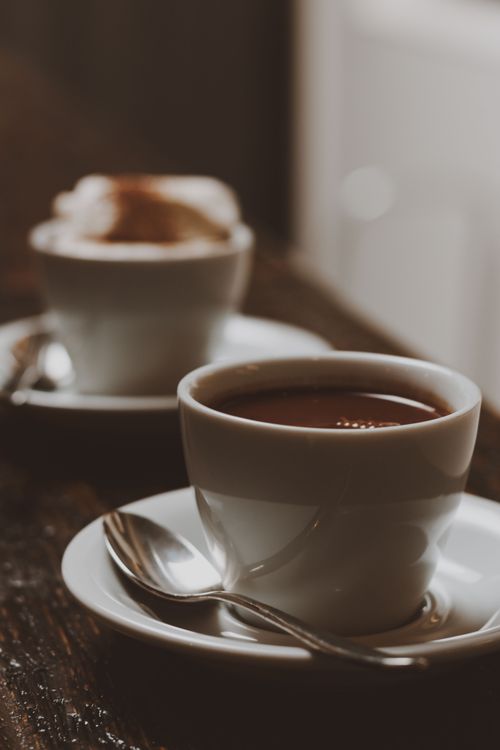 Free A close-up of a freshly brewed coffee cup on a wooden table, evoking warmth and comfort. Stock Photo