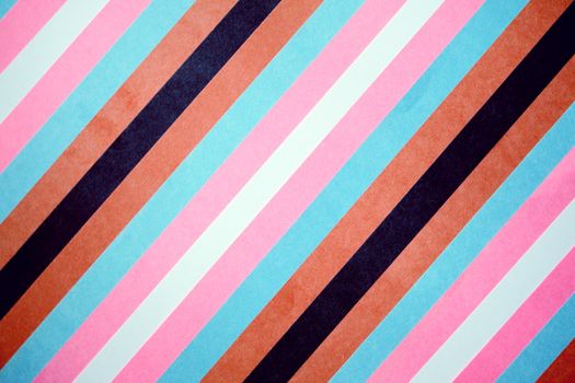 Vibrant diagonal stripes in pink, blue, and brown create a lively pattern.