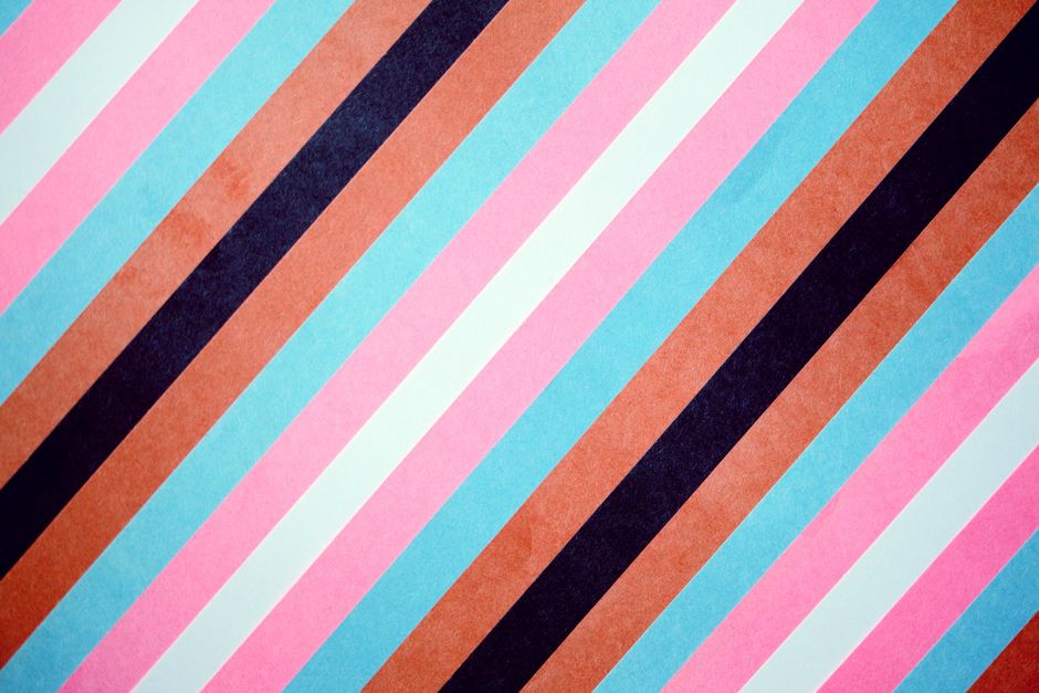 Vibrant diagonal stripes in pink, blue, and brown create a lively pattern.