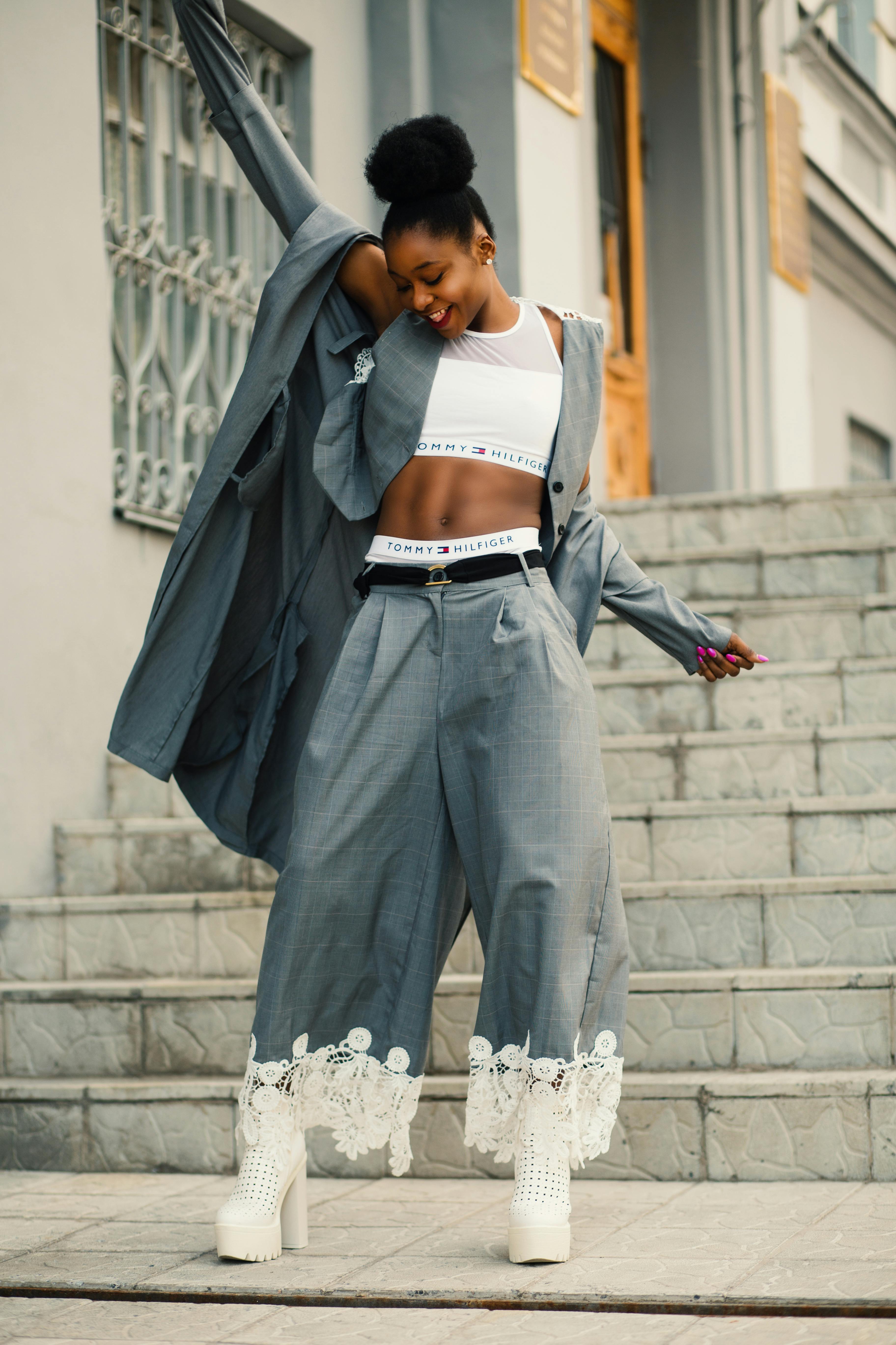 woman in gray blazer stands on gray concrete floor