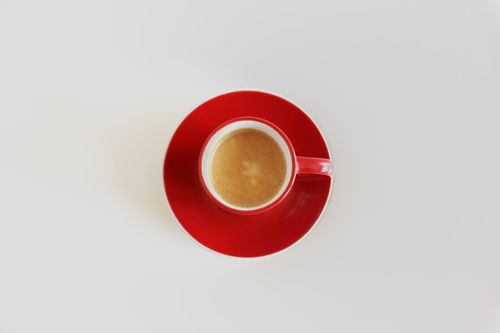 Free Top view of a red cup with espresso on a white surface, showcasing minimalism. Stock Photo