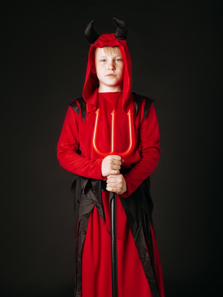 A Boy In Devil Costume Holding A Trident