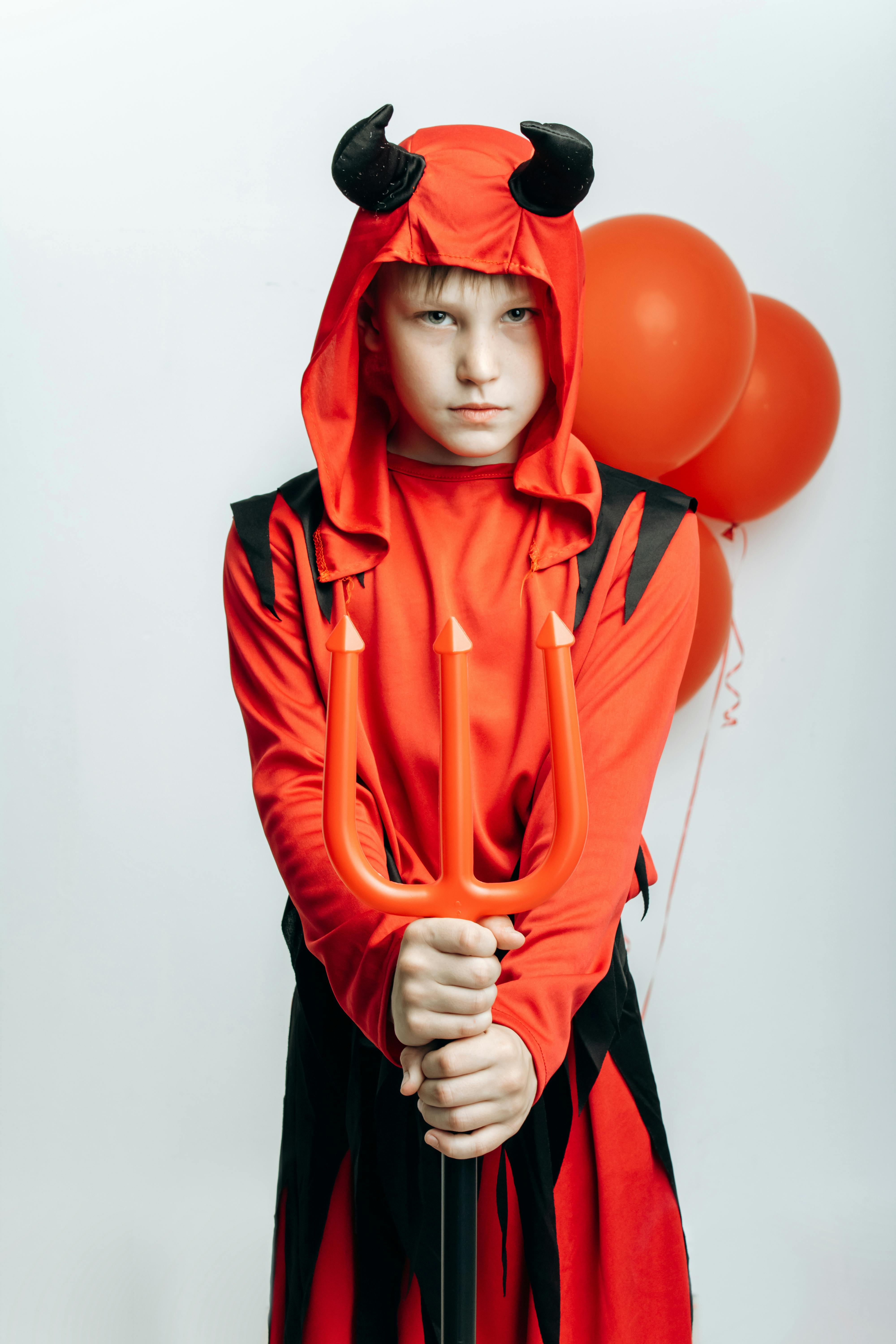 scary boy in devil costume holding a trident