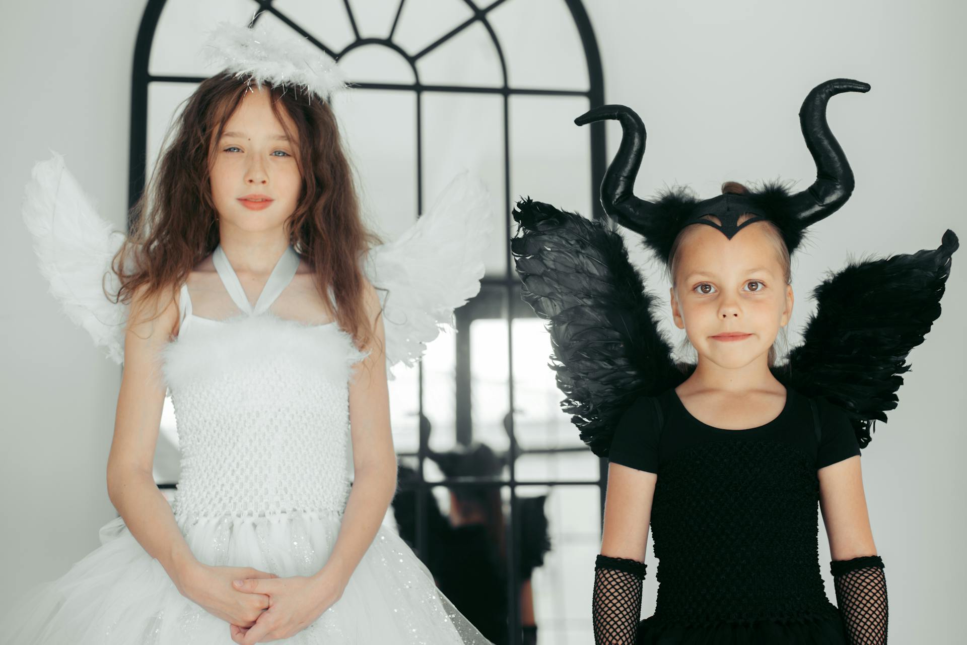 Girl in White Dress Standing beside a Girl in Black Dress