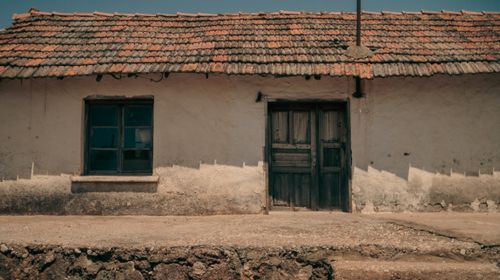 Free A vintage house facade with a wooden door and window, showcasing rustic architecture. Stock Photo