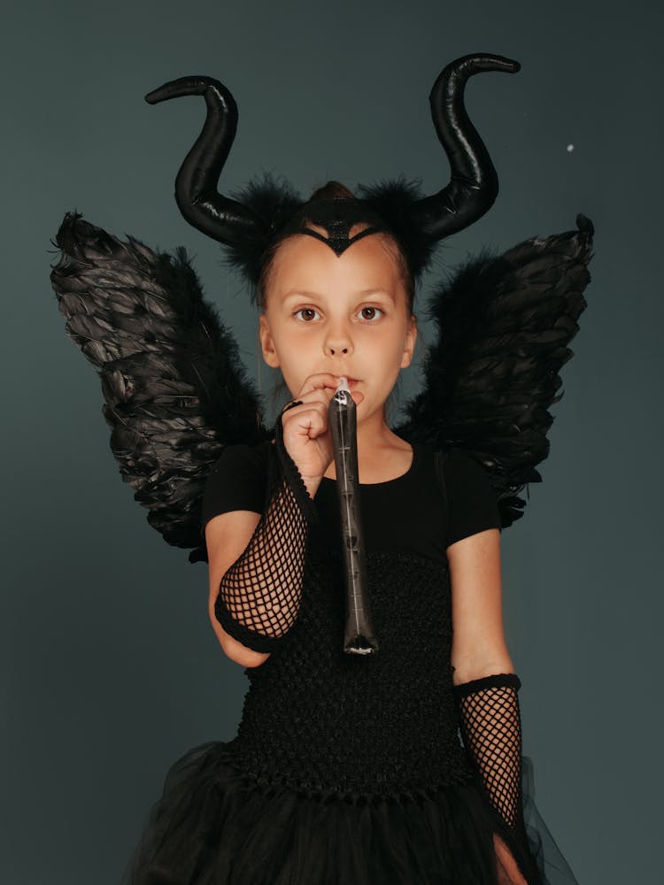 Girl In Black Devil Costume Holding Black Whistle