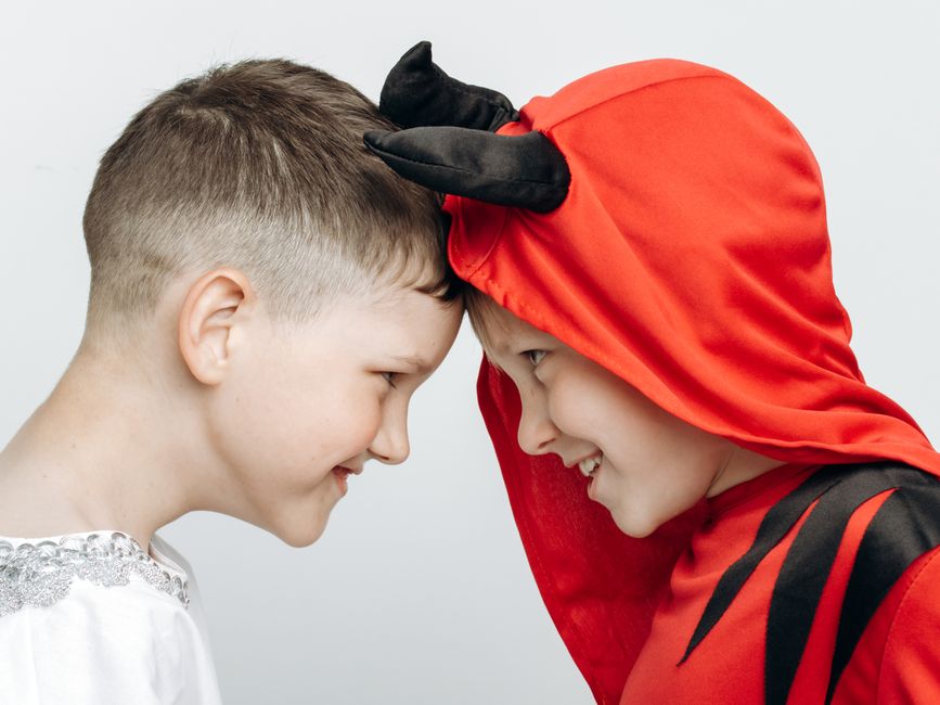 Acting & Improv for Kids 2 Two children dressed as an angel and a devil sharing a playful moment with smiling faces. | BocaVibe