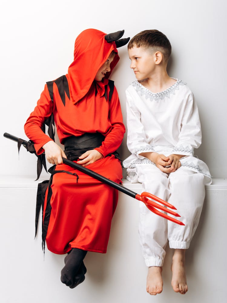 Kids In Costumes Sitting On A Concrete Bench