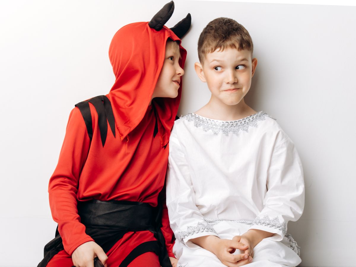 Two children in Halloween costumes having fun together.