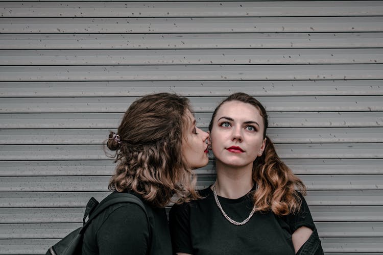 Women Couple Kissing On Wall Background