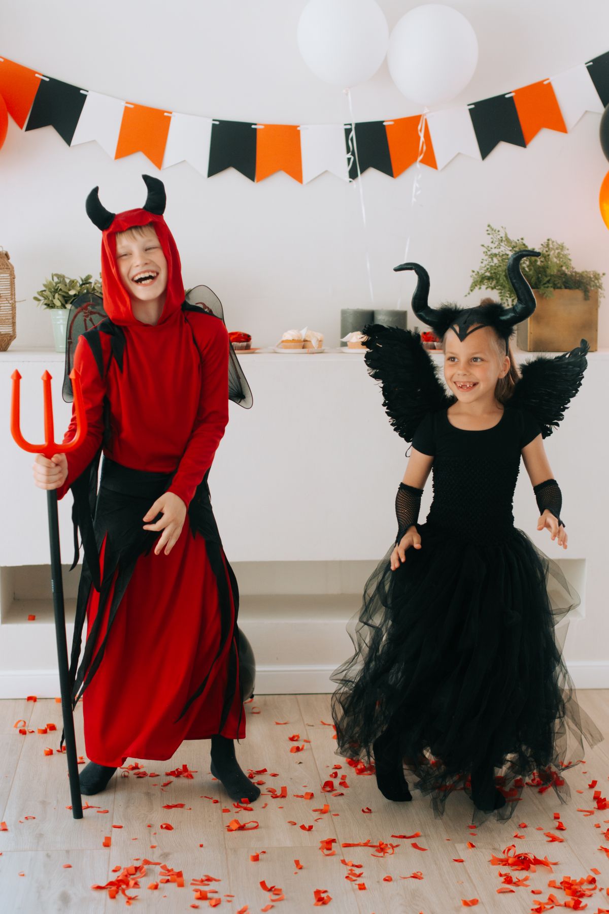 Children laughing together in Halloween costumes.