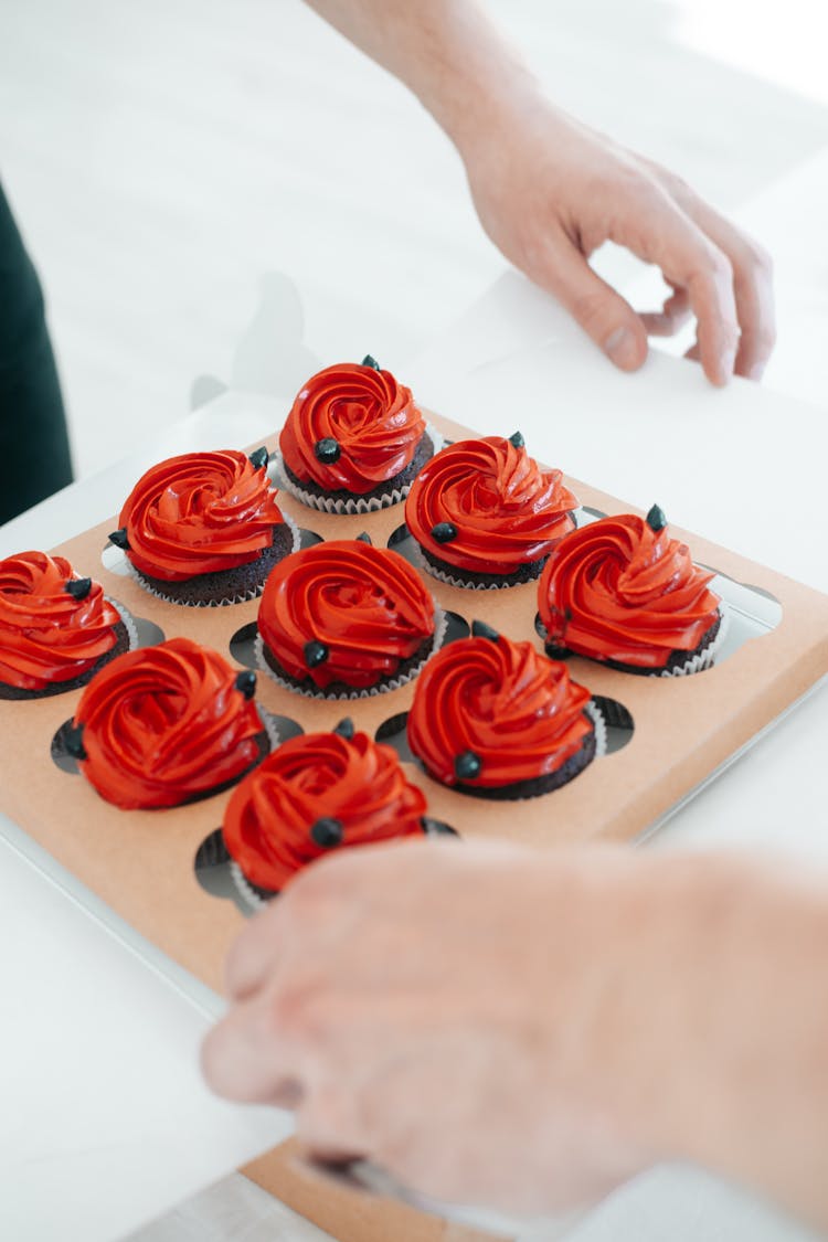 Close-Up Shot Of A Person Holding A Tray Of Cupcakes