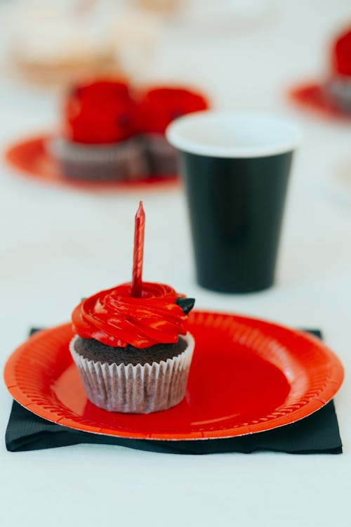 Shallow Focus Photo of Delicious Cupcake on Red Plate