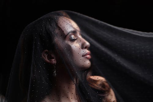 A Side View of a Woman Wearing a Veil with Her Eyes Closed