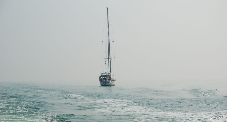 Incredible Private Amalfi Coast Boat Trip from Positano, Praiano or Amalfi Review: The Ultimate Italian Coastal Experience Review 2026 - A lone sailboat navigates the calm misty waters, creating a serene maritime scene.