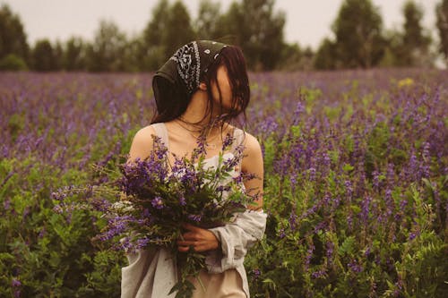 A Woman Collecting Flowers in the Flower Field