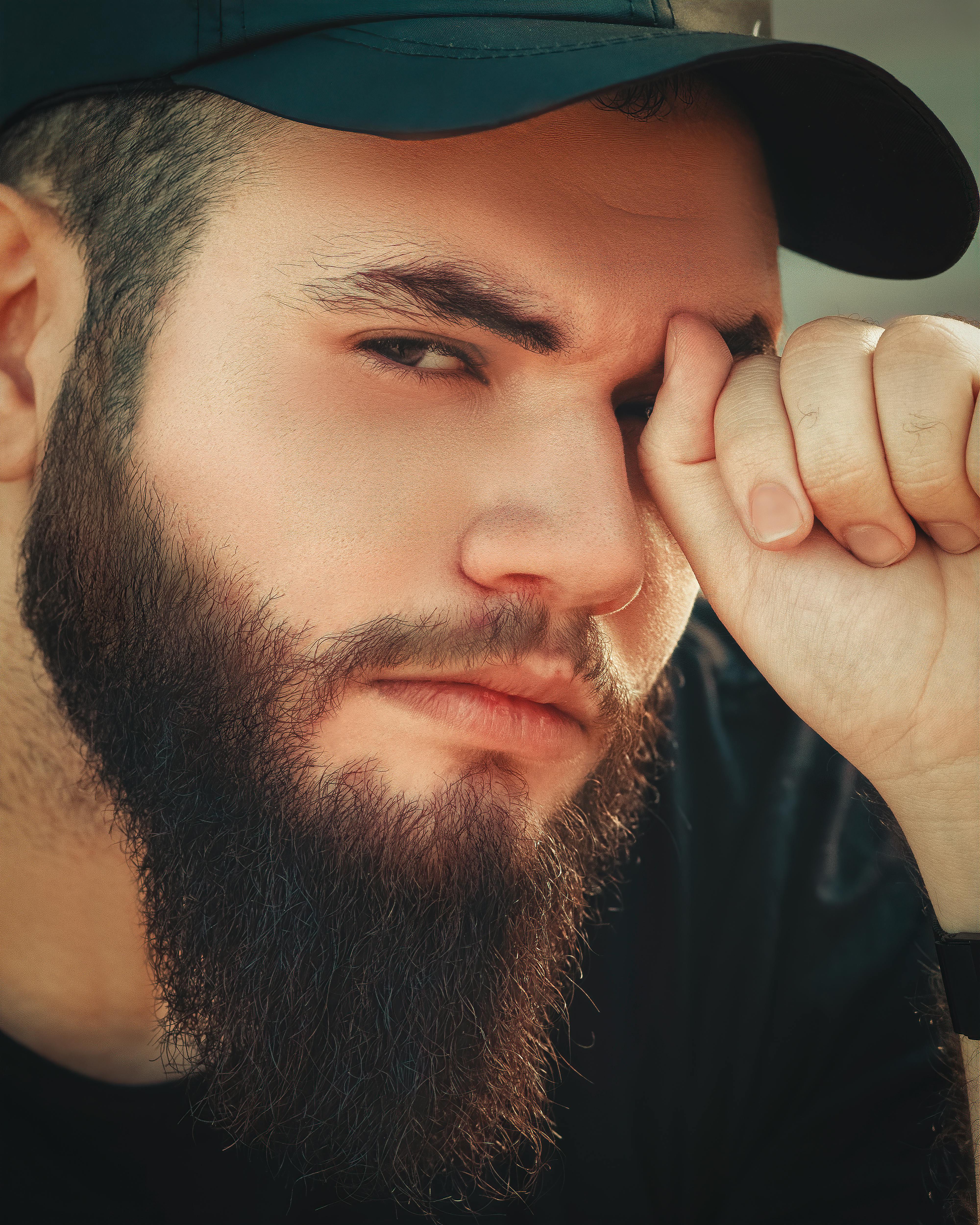 close up shot of a bearded man wearing a cap